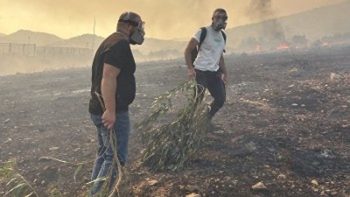 Μέλη του ΚΚΕ βοηθάνε στην κατάσβεση της φωτιάς στα Καλύβια