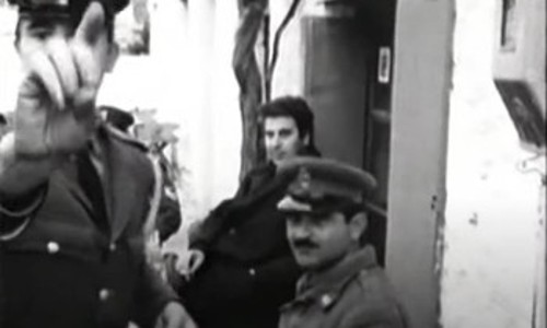 Στιγμιότυπο από πλάνα που τράβηξε στη Ζάτουνα γερμανικό συνεργείο, με τους αστυνομικούς που συνόδευαν τον Μίκη να αντιδρούν στην παρουσία της κάμερας