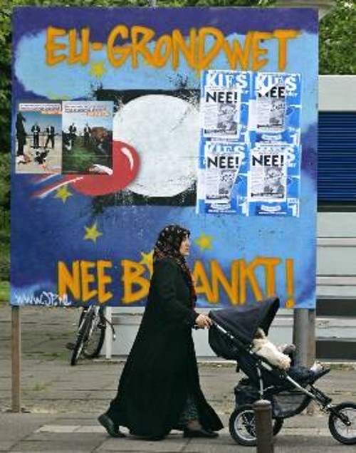 Μια γυναίκα περνά με το μωρό της μπροστά σε γιγαντοαφίσα, σε δρόμο της Ολλανδίας, που γράφει:«Ευρωπαϊκό σύνταγμα - ΟΧΙ ευχαριστώ»