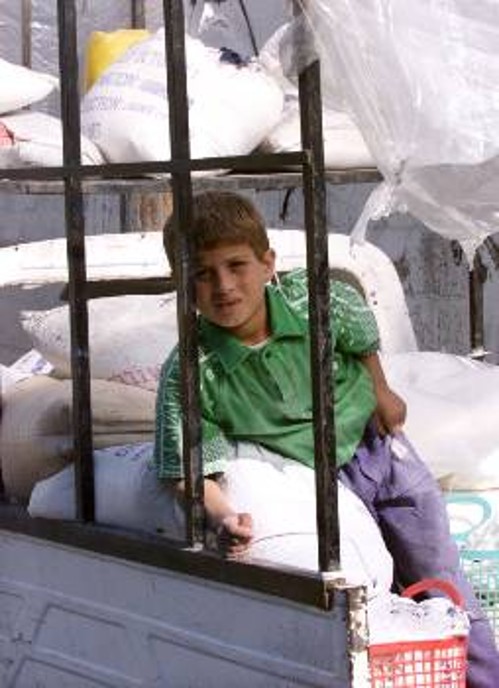Ενα παιδί βοηθά στη μεταφορά των τροφίμων που διανέμει ο ΟΗΕ στους Παλαιστίνιους. Ο αποκλεισμός έχει τρομερές οικονομικές συνέπειες...
