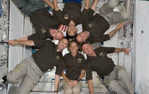 Το πλήρωμα της αποστολής STS-124 του Διαστημικού Λεωφορείου ποζάρει για το φακό σε συνθήκες «έλλειψης βαρύτητας», μέσα στο Kibo, το νέο ιαπωνικό τμήμα του ΔΔΣ. Στο «πάνω» μέρος ο Ιάπωνας αστροναύτης, Ακιχίκο Χοσίντε