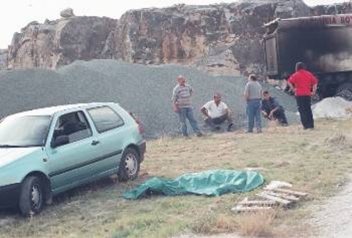 Πέντε ώρες σχεδόν μετά το «ατύχημα», ο 30χρονος οδηγός κείτονταν ακόμα νεκρός στο λατομείο. Στο βάθος το καμένο φορτηγό
