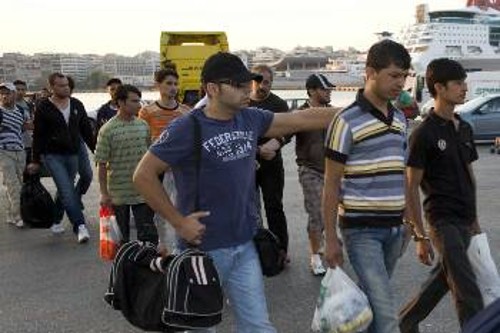 Ανάμεσα στους μετανάστες, αστυνομικοί τους πηγαίνουν προς τα λεωφορεία