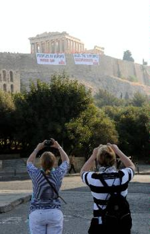 Τουρίστες φωτογραφίζουν τα πανό του ΚΚΕ στην Ακρόπολη