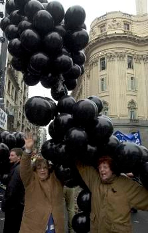 Διαδηλώτριες κρατούν μαύρα μπαλόνια, σύμβολο «πένθους» για τις περικοπές μισθών και συντάξεων