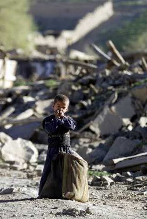 Ενα μικρό αγόρι στέκεται μπροστά στα συντρίμμια κτιρίου που κατέρρευσε από τους σεισμούς. Η παροχή βοήθειας στους πληγέντες δυσκολεύει όλο και περισσότερο