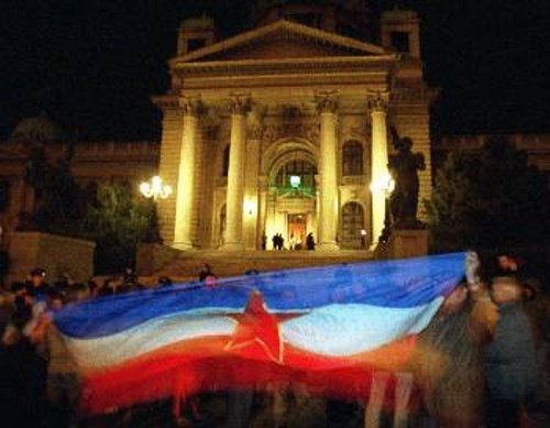 Οπαδοί του Β. Στοϊλίκοβιτς ανοίγουν την παλιά σημαία των κομμουνιστών της Γιουγκοσλαβίας μπροστά από το κτίριο του Κοινοβουλίου