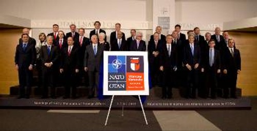 Οι υπουργοί των Εξωτερικών του ΝΑΤΟ με το λογότυπο της Συνόδου Κορυφής της λυκοσυμμαχίας, που θα γίνει το 2016