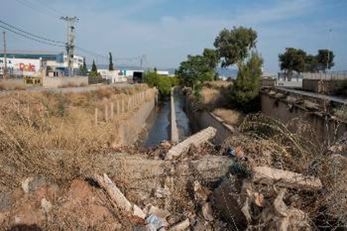 Λίγο πιο κάτω από την πρώτη είσοδο της Μάνδρας το παλιό αντιπλημμυρικό έργο, μετά το νέο, που συνεχίζει προς τη Μαγούλα. Θα δέχεται τα νερά των ρεμάτων Αγ. Αικατερίνης και Σούρες. Ακόμα φαίνονται τα φερτά υλικά από την πλημμύρα του 2017 πάνω από το έργο, αλλά και πάνω στο τοιχίο