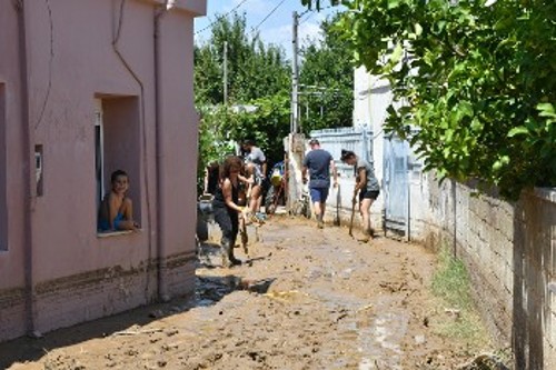 Οι κάτοικοι με φτυάρια και σκούπες προσπαθούν να απομακρύνουν όση λάσπη μπορούν από τα σπίτια τους