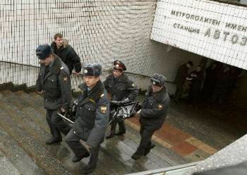 Αστυνομικοί μεταφέρουν τα πτώματα έξω από το σταθμό του μετρό στη Μόσχα
